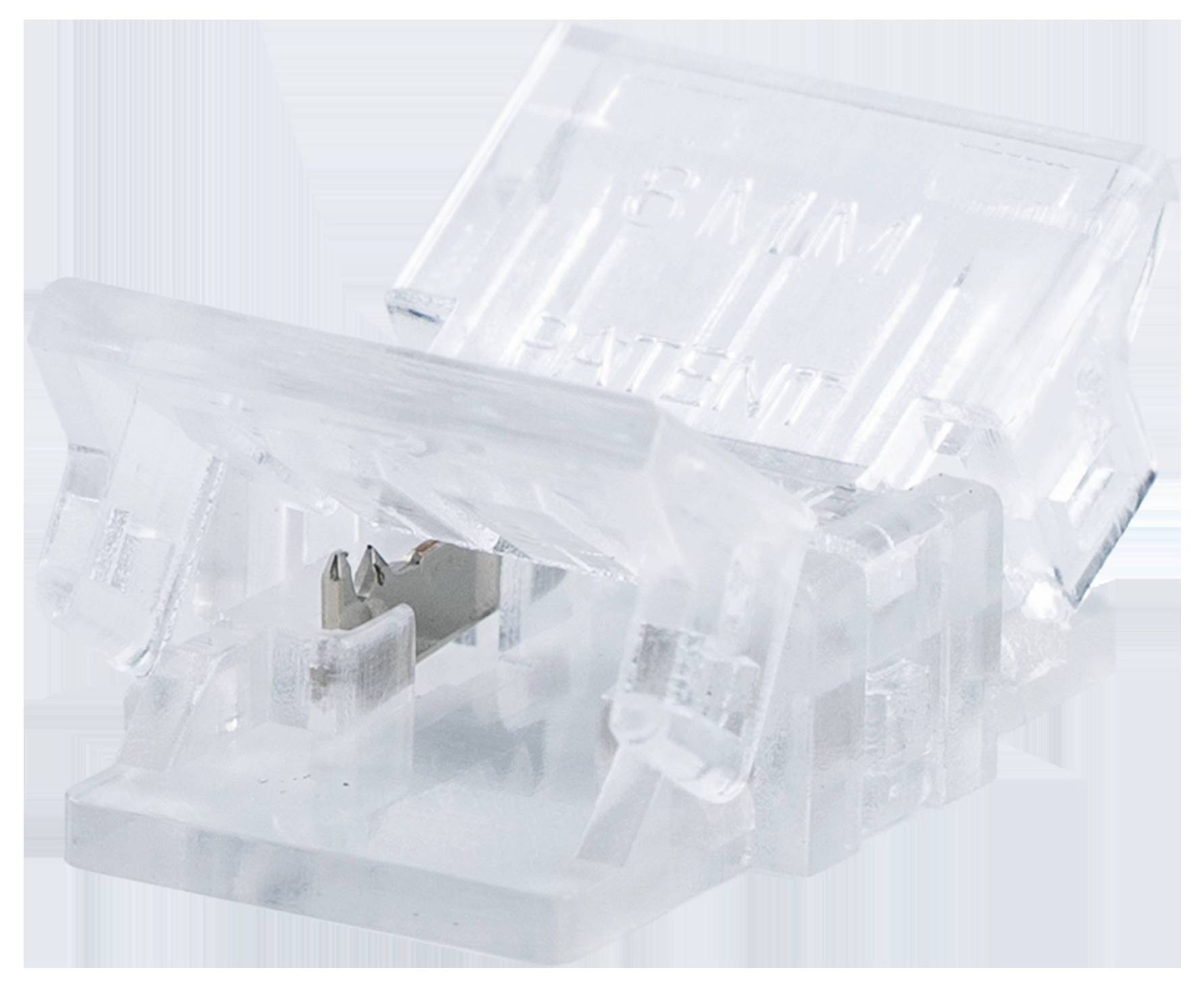 Ein transparenter Clip mit einer metallischen Komponente im Inneren, möglicherweise ein Stecker oder Befestiger, der auf einer weißen Oberfläche ruht.