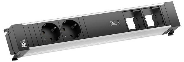 Steckerleiste mit zwei europäischen Steckdosen, USB-Anschluss und zwei Steckplätzen für zusätzliche Module. Schwarzes und silbernes Design, Marke 'BACHMANN'.