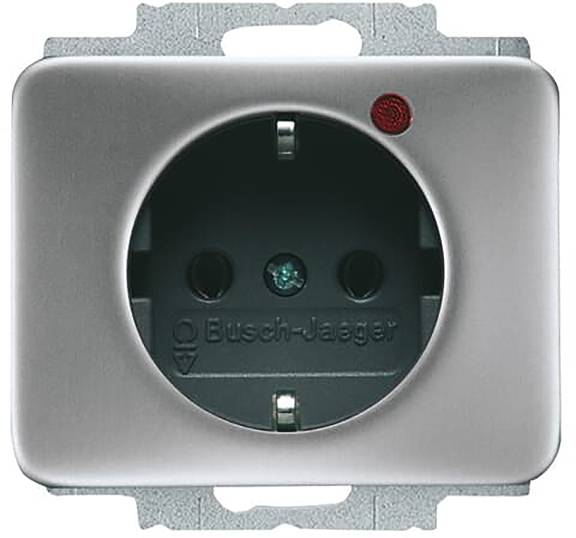 Silberne elektrische Wandsteckdose mit zwei runden Steckplätzen, einem Erdungsstift und einer roten Kontrollleuchte in der oberen rechten Ecke.