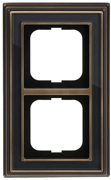 Eine doppelte Lichtschalterabdeckung mit Bronze- und Schwarzlackierung, mit zwei rechteckigen Öffnungen für Schalter.