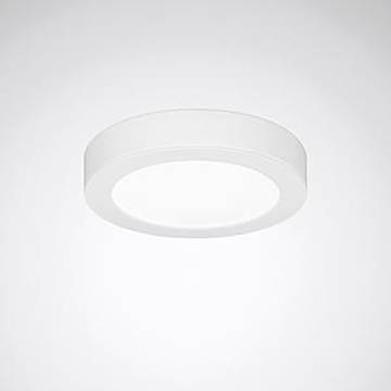 Eine kreisförmige, bündig montierte weiße Deckenleuchte, die weiches weißes Licht ausstrahlt, zentriert vor einem einfachen grauen Hintergrund.