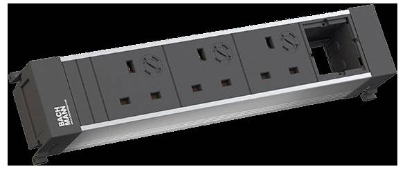 Stromleiste der Marke 'Bachmann' mit drei UK-Steckdosen und einem offenen Schlitz auf der rechten Seite für Erweiterungen.