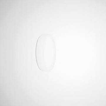 Ein weißes, keramisches, oval geformtes Objekt, das an einer hellgrauen Wand angebracht ist und einen weichen Schatten nach rechts wirft.