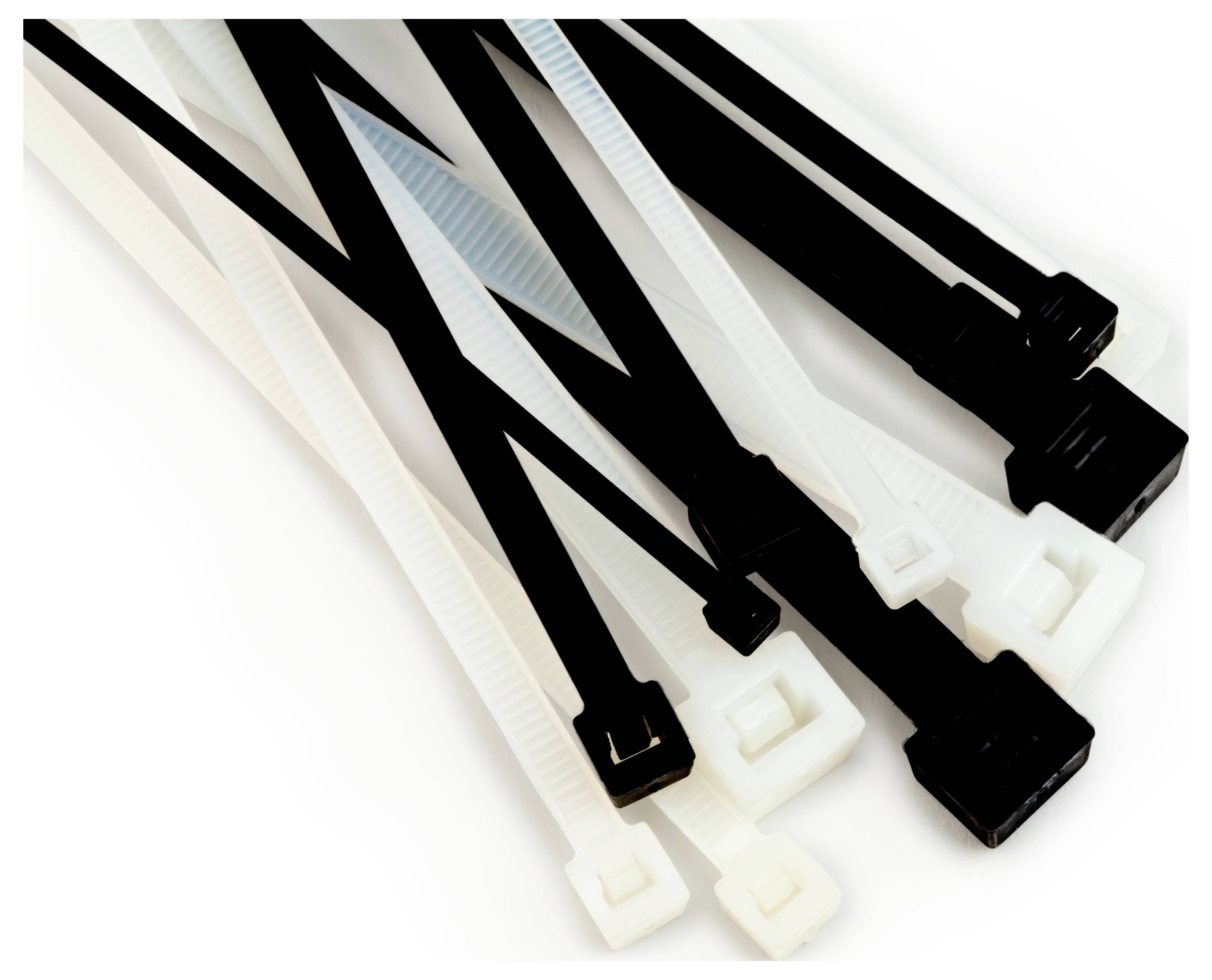 Schwarze und weiße Kunststoffkabelbinder in verschiedenen Größen sind nebeneinander auf einer ebenen Oberfläche angeordnet.