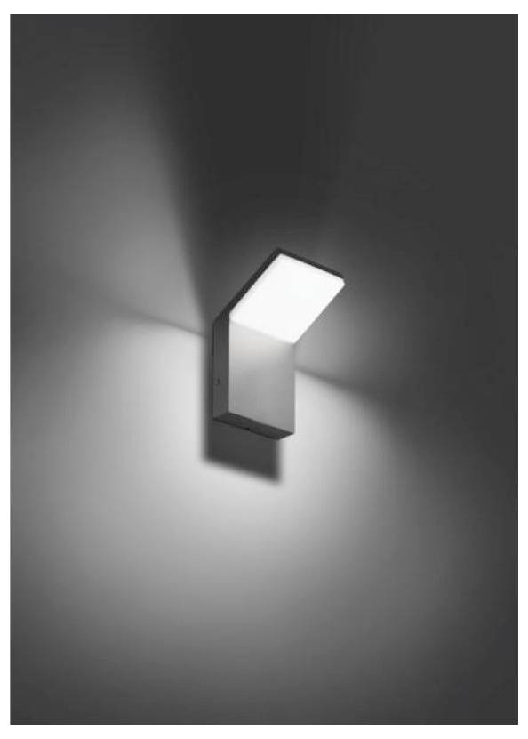 An der Wand montierte moderne Wandleuchte, die einen hellen dreieckigen Strahl auf eine schlichte Wand wirft.