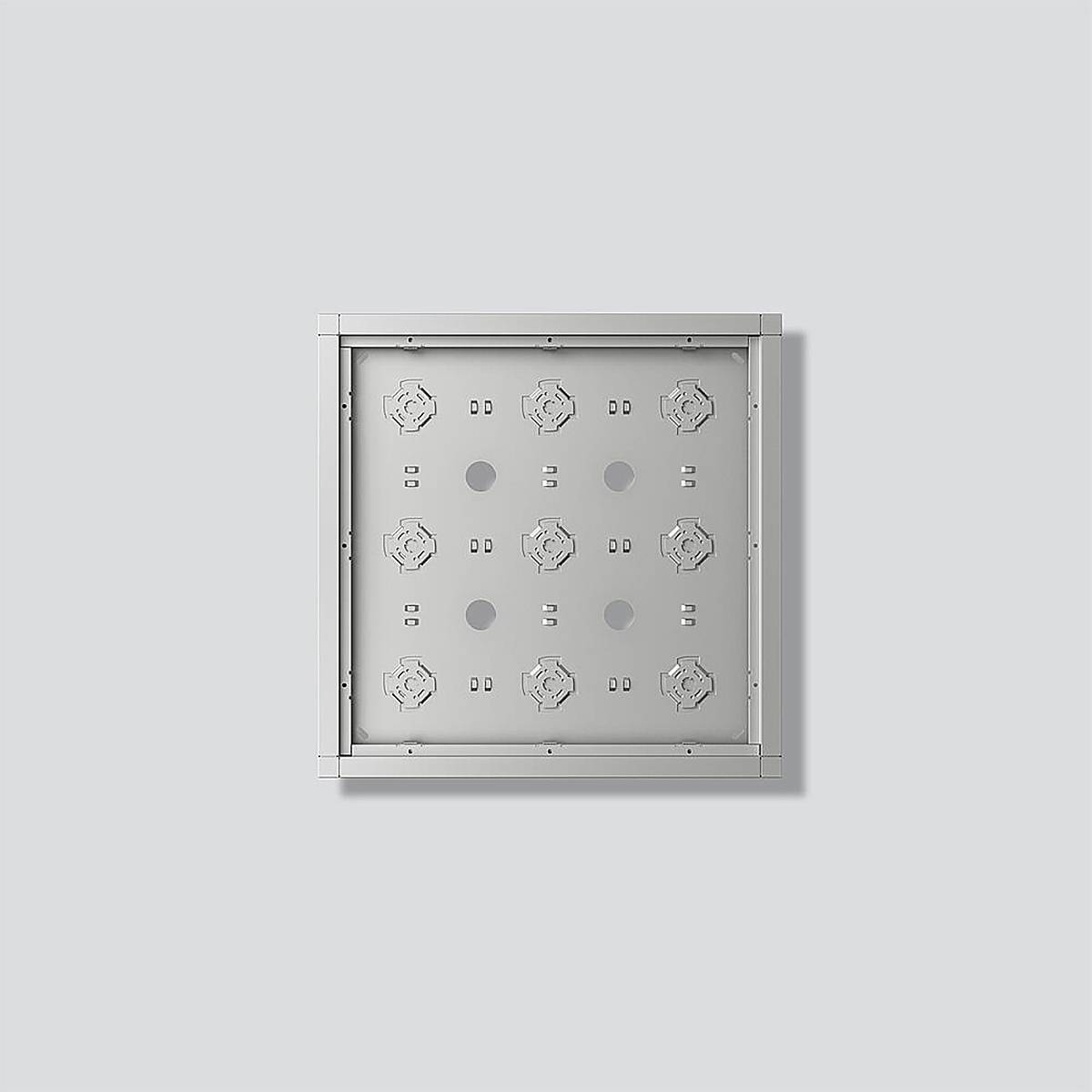 Metallisches quadratisches Paneel mit geometrischen Mustern und kreisförmigen Ausschnitten, auf hellgrauem Hintergrund montiert, wirft einen sanften Schatten.