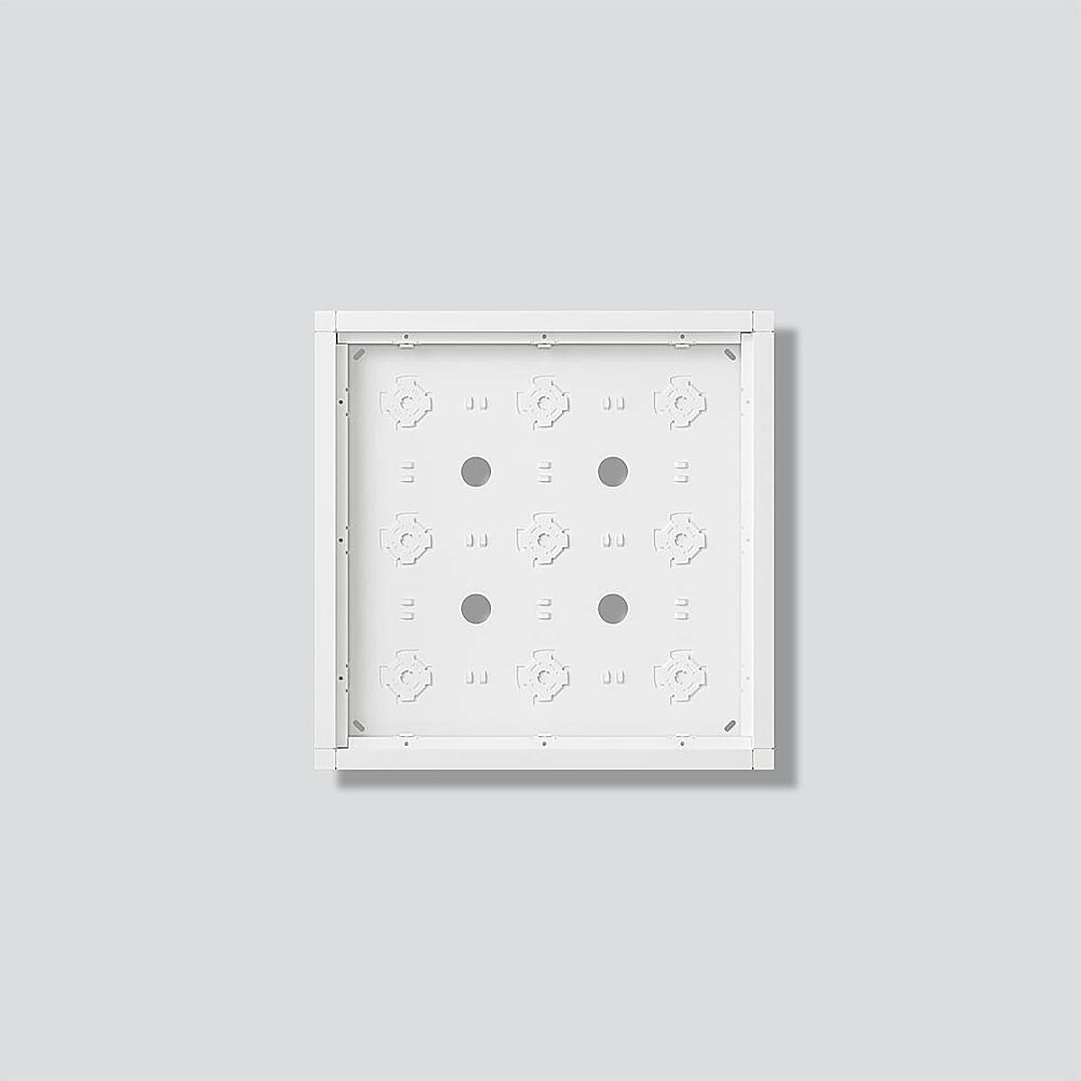 Quadratisches weißes Panel mit mehreren kreisförmigen Ausschnitten und geometrischen Formen vor einem hellgrauem Hintergrund.