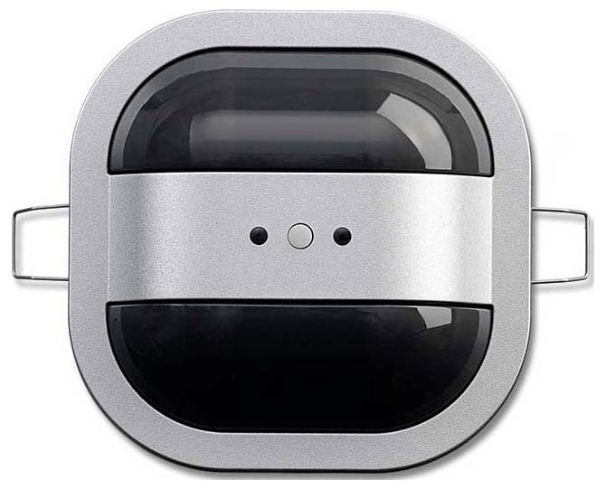 Kompaktes quadratisches Gerät mit zwei schwarzen Linsen, die wie Augen wirken, und einem metallischen Rahmen, möglicherweise ein technisches Gadget oder Sensor, von oben betrachtet.