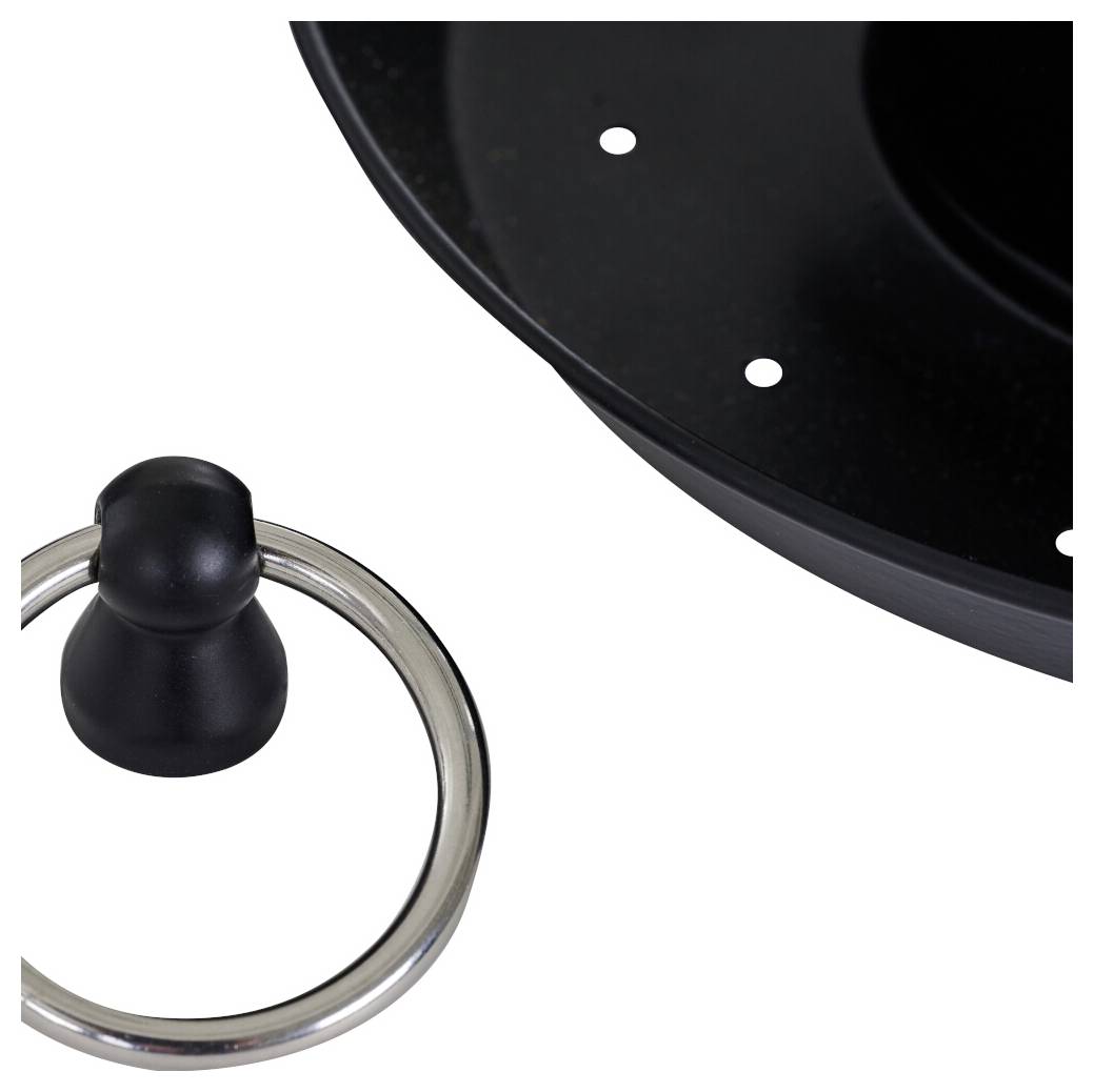 Ein runder Metallring, der an einem schwarzen Knopf befestigt ist, liegt neben einer schwarzen Oberfläche mit kleinen Löchern, die einem Teil eines Küchengeräts ähnelt.