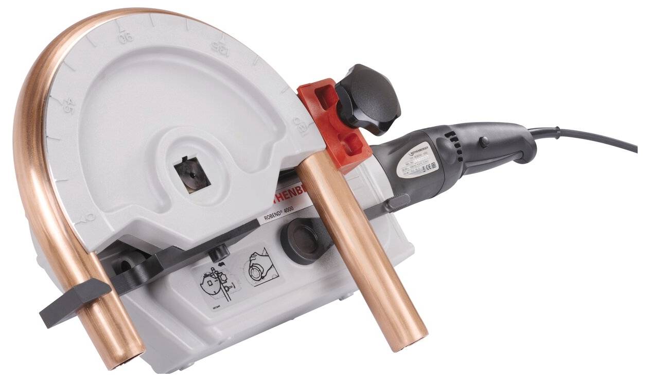 Rohrbiegemaschine mit Kupferrohr in Biegeposition, Bedienelemente auf dem Gerätepanel sichtbar.