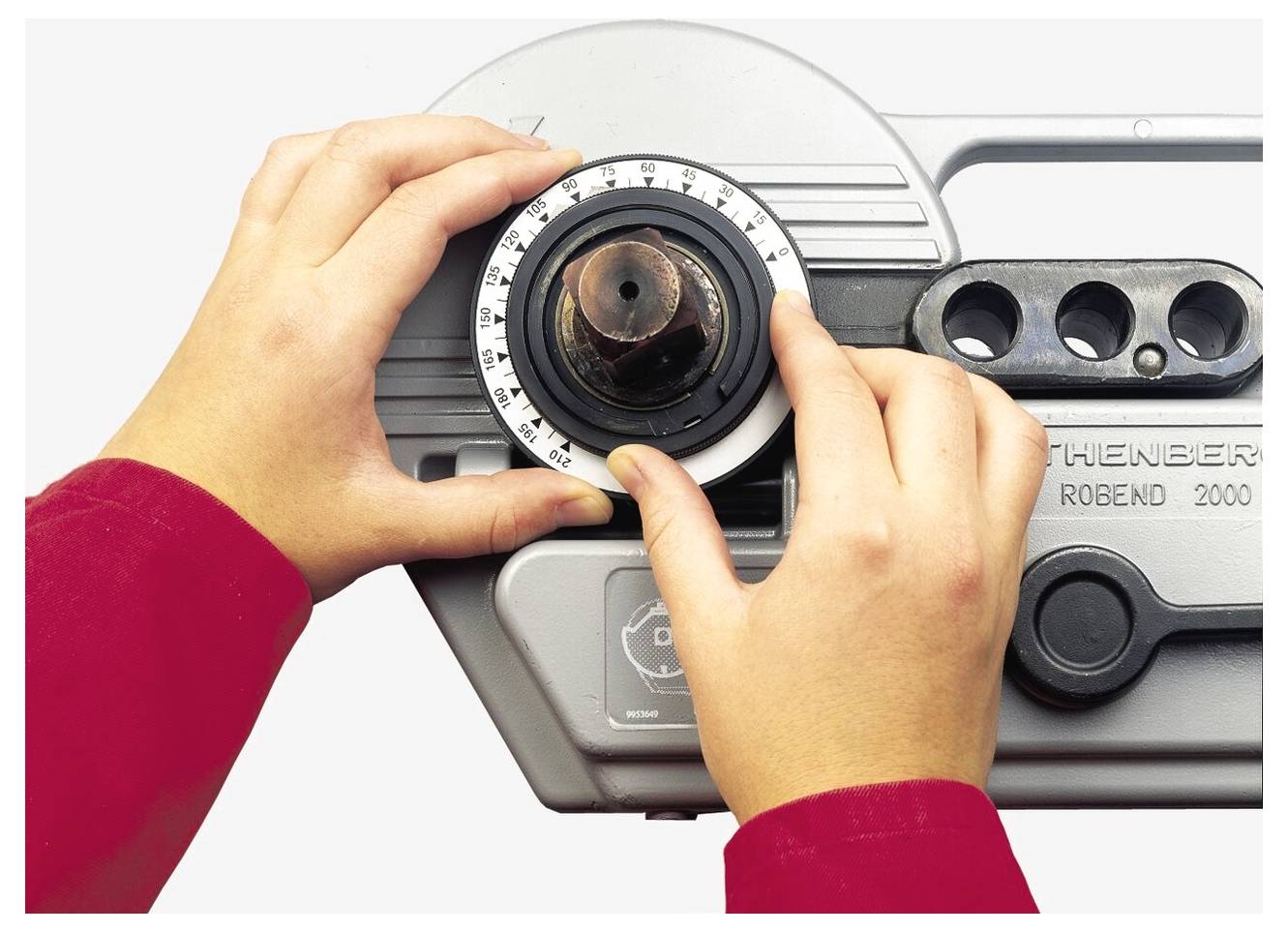 Zwei Hände justieren einen Knopf an einer Maschine mit der Aufschrift ROBEND 2000 und platzieren einen Zeiger auf einer halbkreisförmigen Skala.