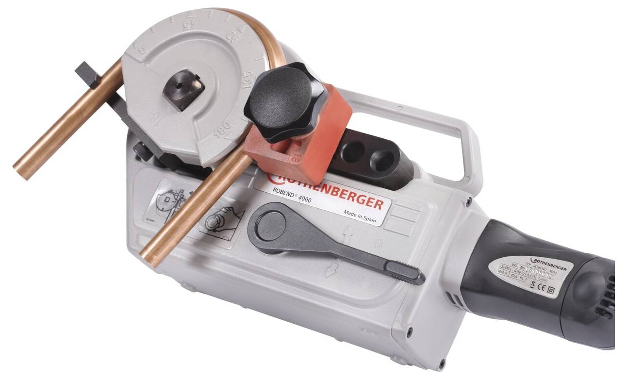Eine Handrohrbiegemaschine von Rothenberger wird gezeigt, die zwei Kupferrohre enthält und mit einem manuellen Hebel und einem Einstellknopf ausgestattet ist.