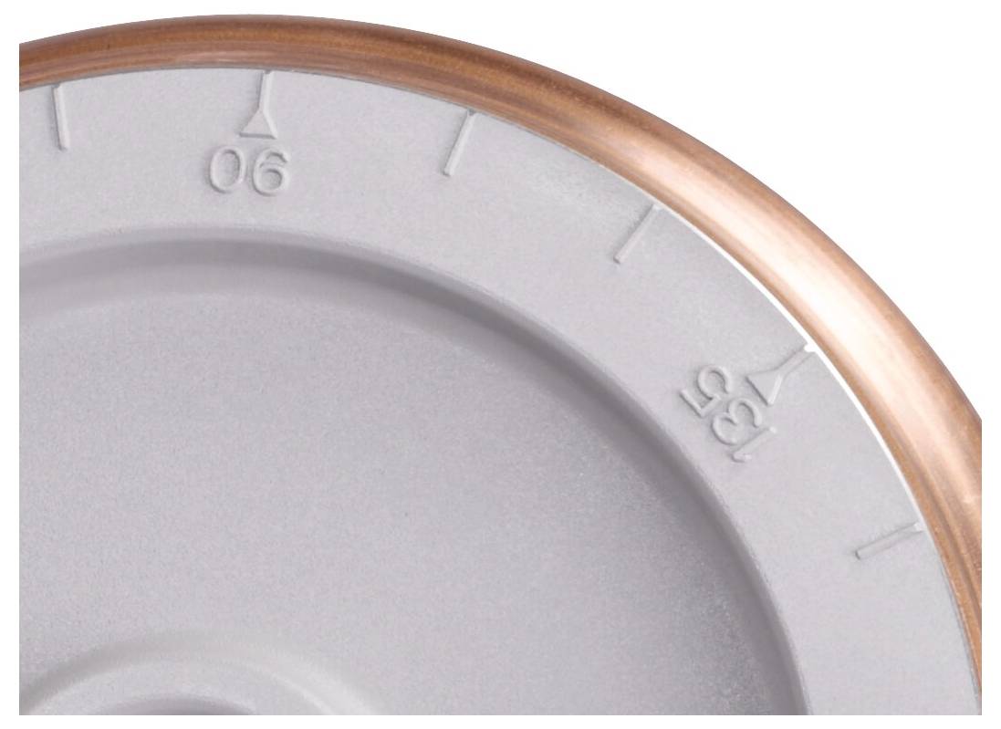 Eine Nahaufnahme eines kreisrunden Zifferblatts zeigt teilweise die Zahlen '06' und '35' mit erhabenen dreieckigen Markierungen und einer kupferfarbenen Kante.
