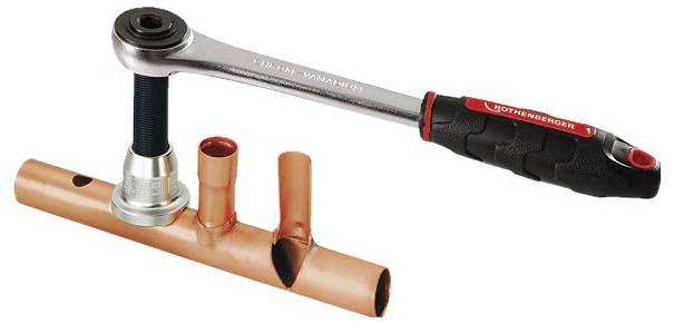 Ein Rohrabschneider-Werkzeug mit Ratschenmechanismus, der eine Kupferrohrleitung für Sanitärinstallationszwecke durchtrennt.