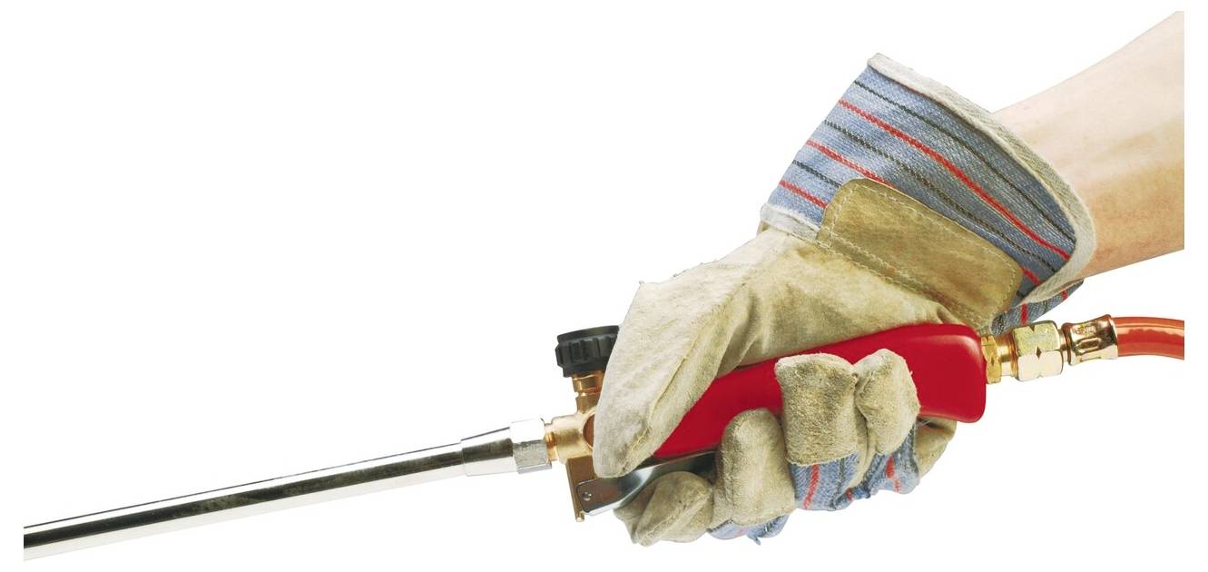 Eine behandschuhte Hand hält einen Schweißbrenner mit rotem Griff, bereit zum Einsatz, was Sicherheitsvorkehrungen und Einsatzbereitschaft für eine Schweißaufgabe andeutet.