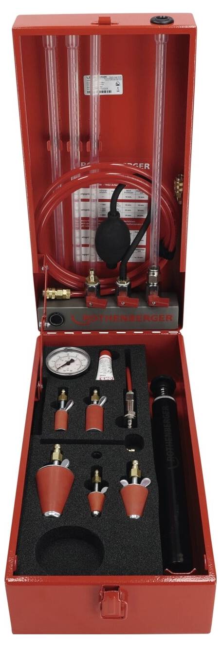 Ein rotes automotives Druckprüfset mit Schläuchen, Anschlüssen, einem Manometer und verschiedenen Adaptern, ordentlich in einem Koffer angeordnet.