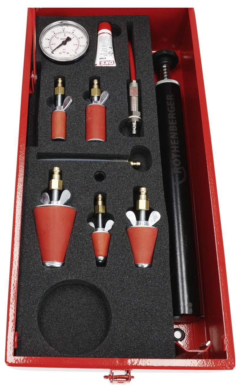 Roter Ausrüstungskoffer, der ein Manometer, verschiedene konische Anschlüsse und eine Tube Schmiermittel in schwarzen Schaumstoffeinlagen enthält.