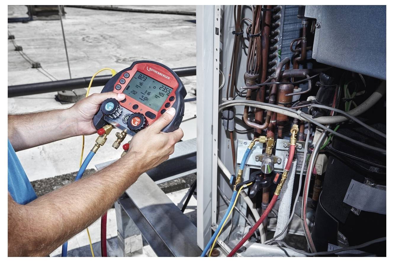 Ein Techniker nutzt ein digitales Verteilermessgerät, um die Drücke in einem HVAC-System zu überprüfen, Ventile einzustellen und verschiedene Rohrleitungen zu überwachen.