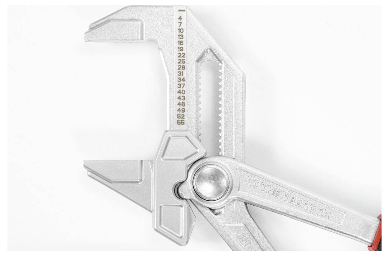 Silberner Schraubenschlüssel mit verstellbarem Maul und Messmarken für präzise Größeneinstellung, aus einem Blickwinkel betrachtet, der seinen Griff und Mechanismus zeigt.