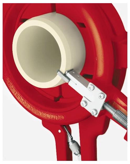 Nahaufnahme eines roten Rohrabschneiders, der ein beiges Rohr umschließt. Die metallische Klinge und der Klemmmechanismus sind sichtbar und betonen seine Schneidefunktion.