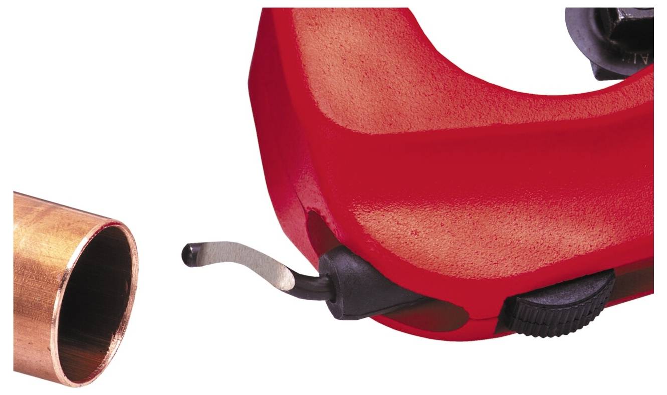 Ein roter Rohrabschneider, der in der Nähe des Endes eines Kupferrohrs positioniert ist und zeigt, dass die Schneidklinge bereit ist, das Rohr zu kürzen.