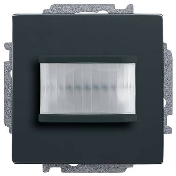 Ein schwarzer quadratischer Bewegungsmeldeswitch mit einem horizontal geriffeltem Sensorfeld in der Mitte, montiert auf einer grauen Grundplatte.