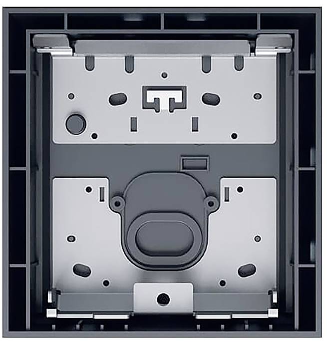 Das Bild zeigt eine metallische Wandmontageklammer mit mehreren Löchern und Befestigungselementen, die zum Sichern eines bündig montierten Geräts ausgelegt ist.