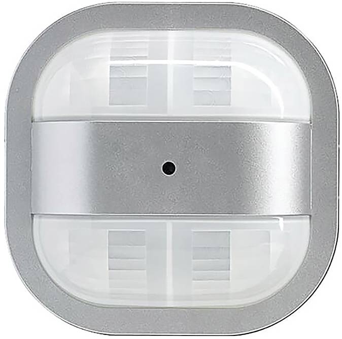 Ein quadratisches Sensorsensorgerät aus silbernem und weißem Kunststoff, möglicherweise zur Bewegungserkennung, mit einem zentralen schwarzen Punkt, liegt auf einer ebenen Oberfläche.