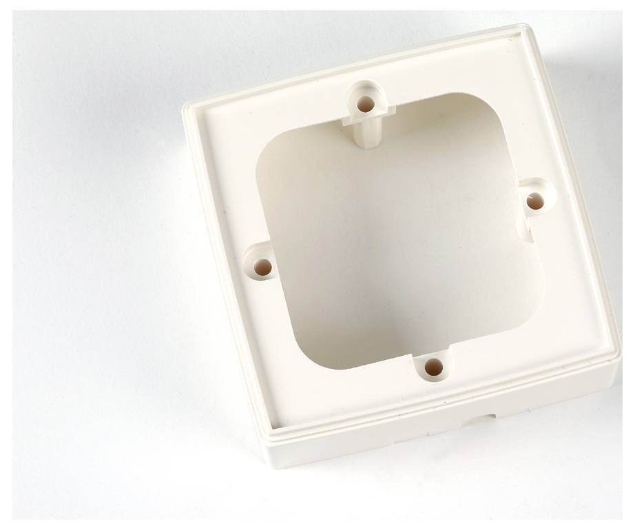 Leere beige Kunststoff-Wandeinbasdose mit vier Schraubenlöchern, konzipiert für die Installation von elektrischen Komponenten oder Schaltern.