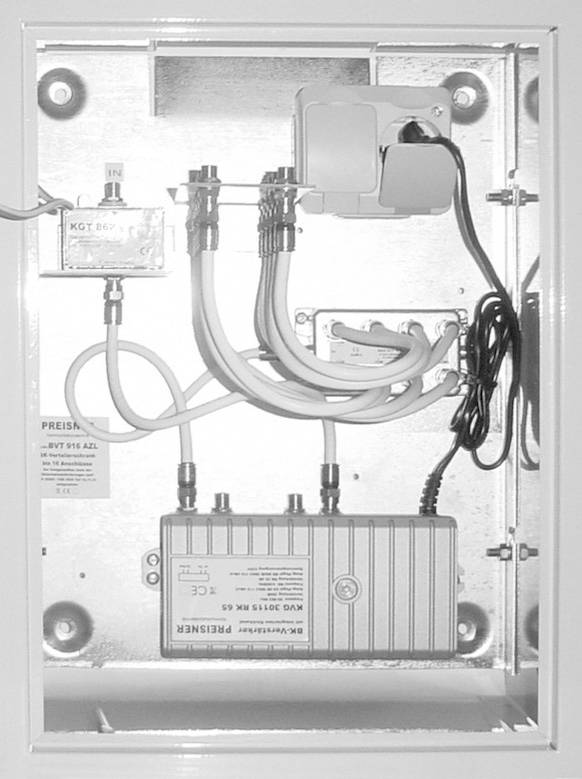 Ein metallischer Elektrokasten mit Kabeln und zwei weißen rechteckigen Geräten, konzipiert zur Verwaltung von Kabelverbindungen.
