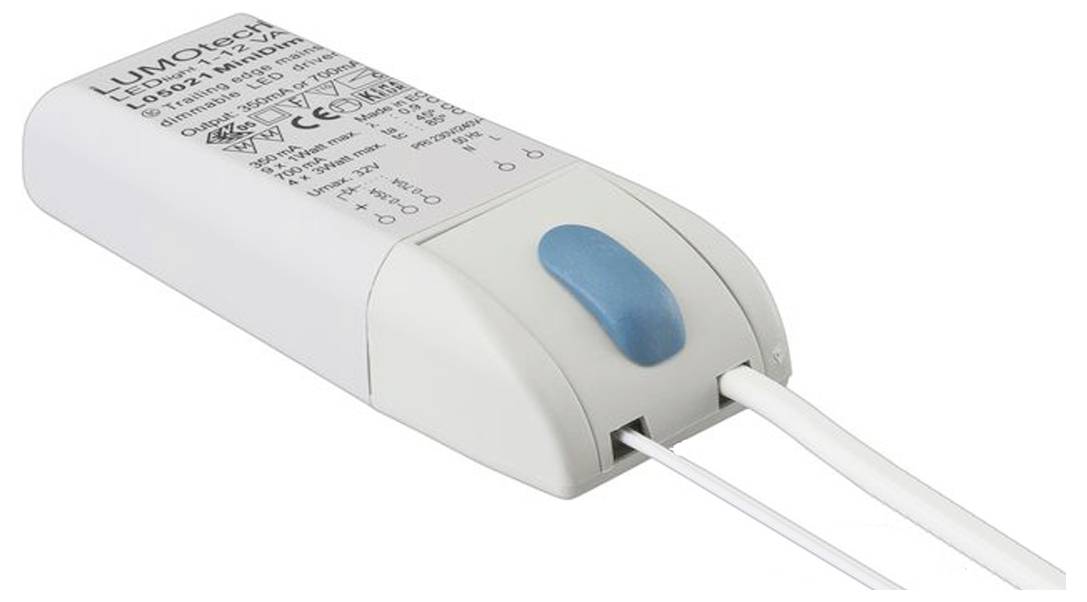 Ein kleines weißes elektronisches Gerät mit einem blauen Knopf und Kabeln, auf dessen Oberfläche Warnhinweise und Stromspezifikationen beschriftet sind.