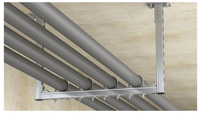 Ein an der Decke montiertes Gestell hält fünf parallel verlaufende Metallrohre sicher, gestützt durch ein robustes Metallrahmen in einer industriellen Umgebung.