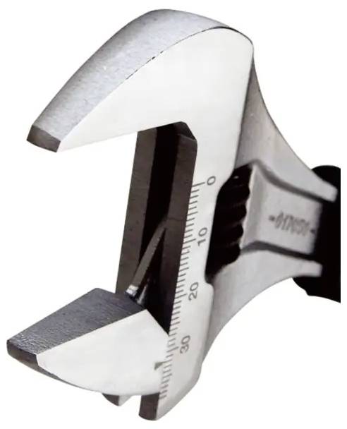 Person mit einem rot-schwarzen Rohrabschneider über einer Werkbank, mit zusätzlichen Sanitärwerkzeugen in der Nähe in einem offenen Koffer.