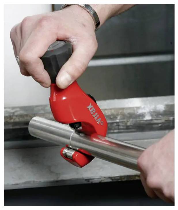 Tragbarer rot-schwarzer Virax-Drucksprüher mit Manometer, Pumpgriff und angeschlossenem Schlauch.