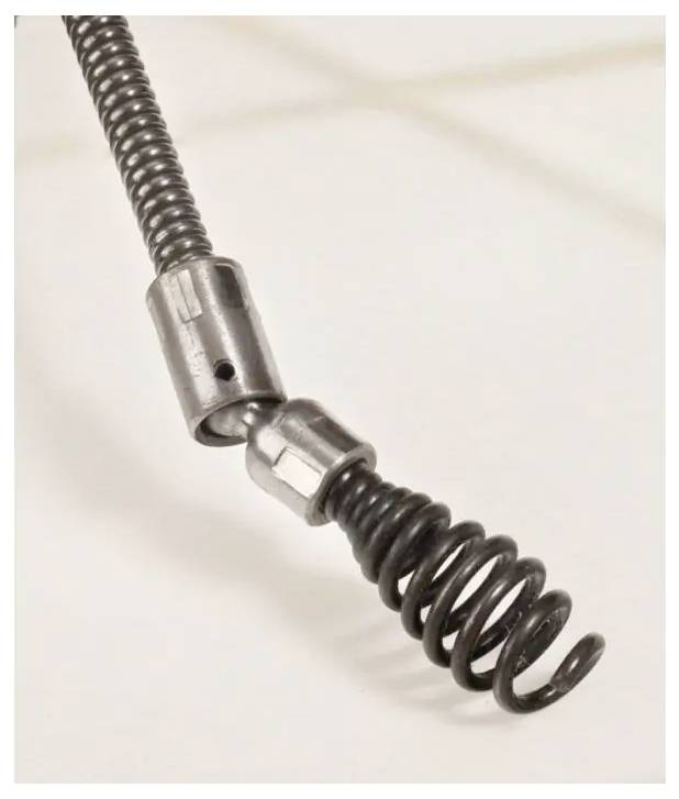 Nahaufnahme eines flexiblen aufgerollten Metallschlauchs oder Kabels mit zwei federartigen Abschnitten, die durch einen Metallverbinder auf einem einfachen Hintergrund verbunden sind.