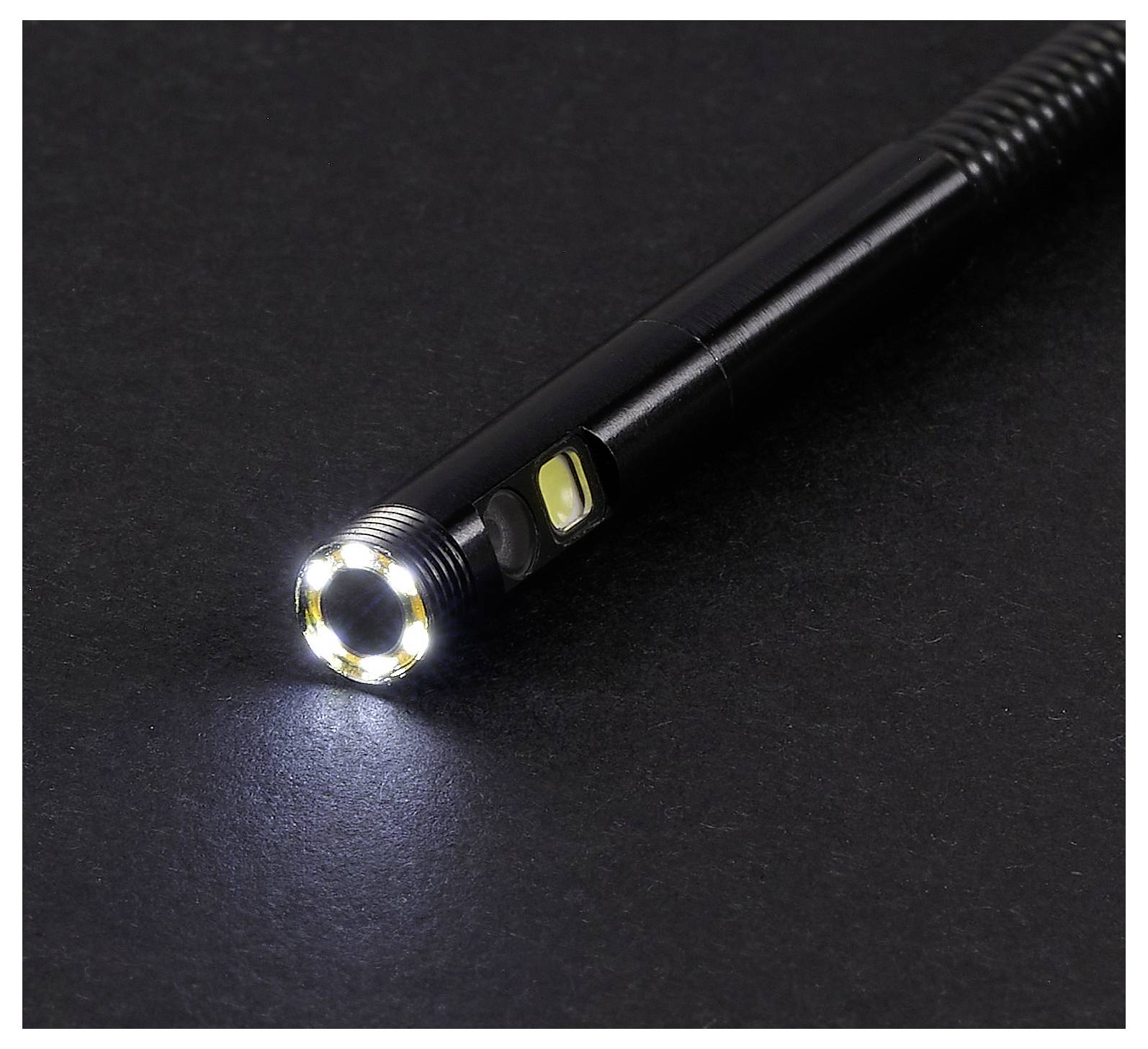 Schwarze tragbare LED-Taschenlampe auf einer dunklen Oberfläche, die einen hellen, kreisförmigen Lichtkegel wirft.