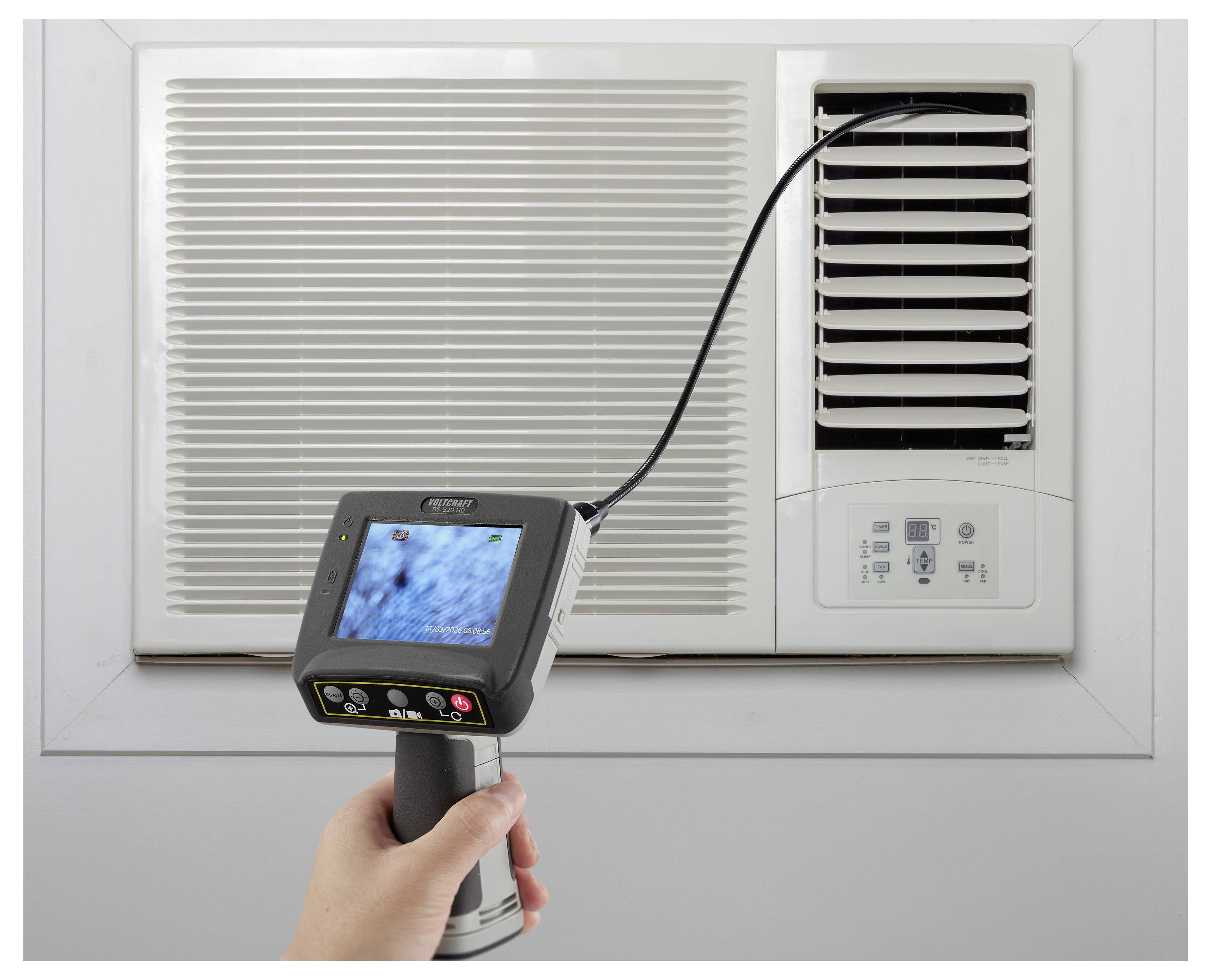 Tragbare Inspektionskamera mit flexiblem Kabel untersucht einen Klimaanlageauslass, wahrscheinlich zur HVAC-Wartung oder Diagnose.
