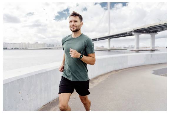 Ein Mann in einem grünen Hemd joggt an einem Flussufer entlang, während im Hintergrund eine Brücke unter einem bewölkten Himmel zu sehen ist.