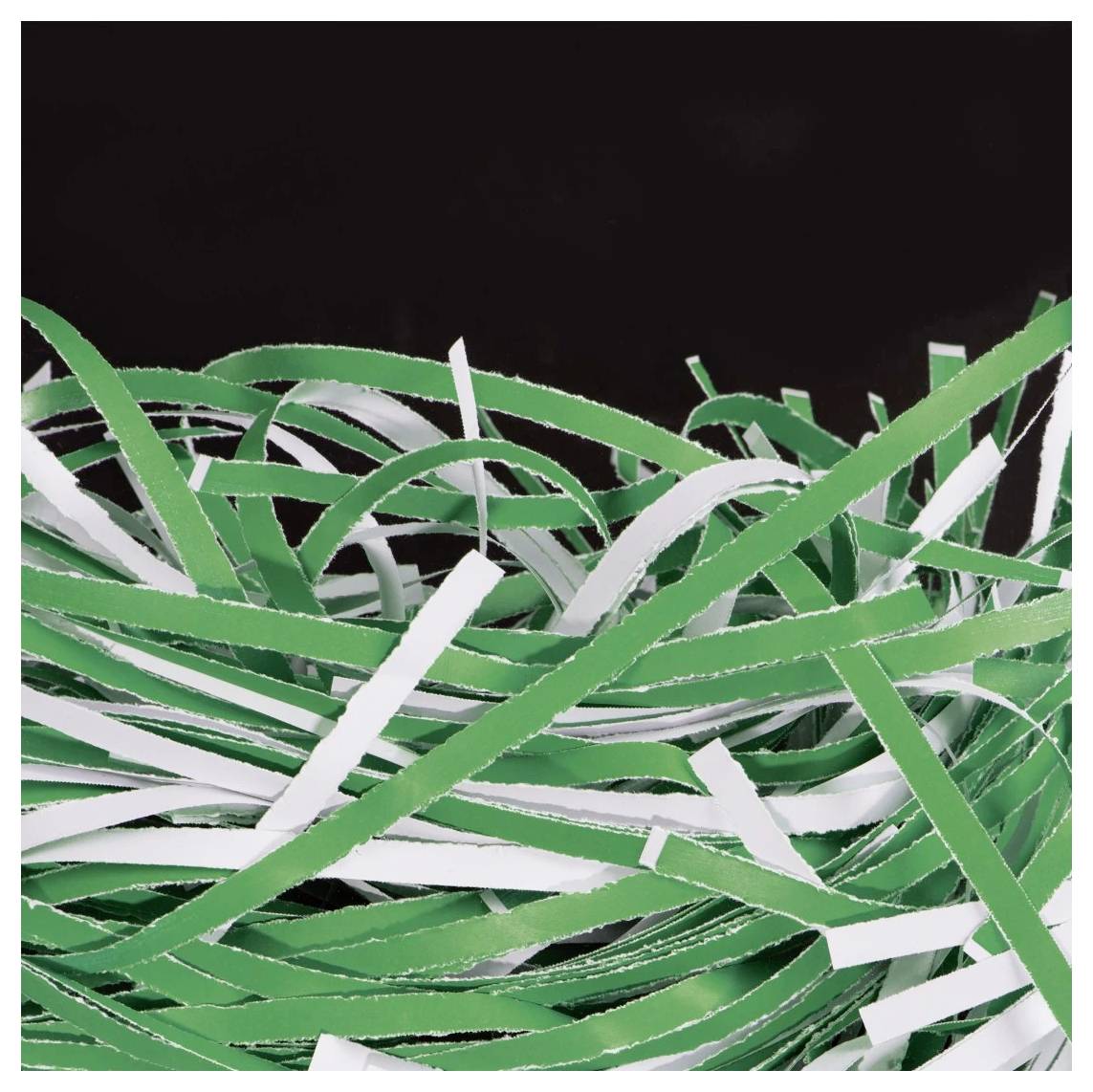 Ein Durcheinander aus zerrissenen grünen und weißen Papierschnipseln, die in verschiedene Richtungen auf einem schwarzen Hintergrund verstreut sind.