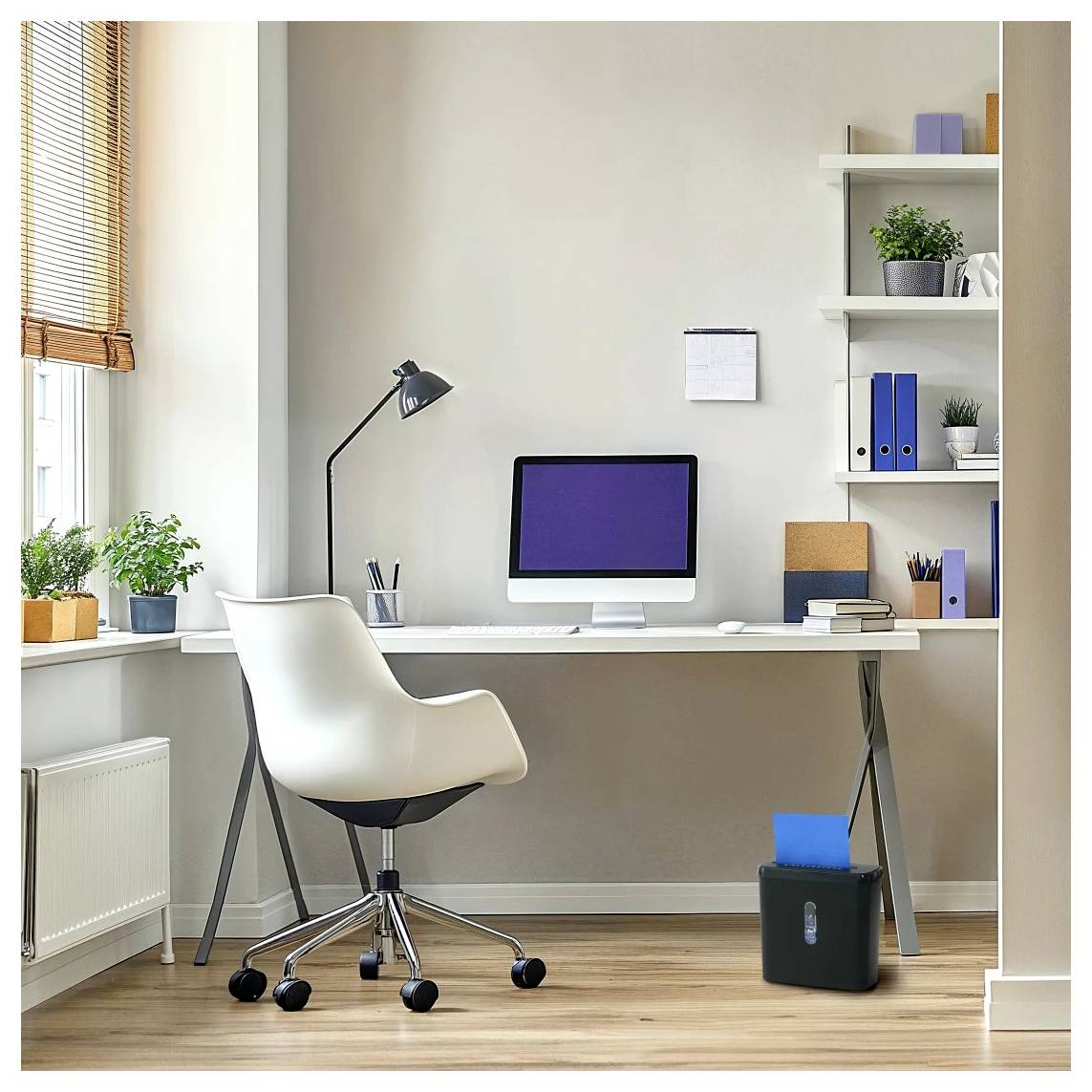 Ein modernes Homeoffice mit einer Schreibtischeinrichtung, die einen Computer, eine Lampe, Pflanzen und Regale umfasst. Ein Aktenvernichter steht auf dem Boden neben dem Schreibtisch.