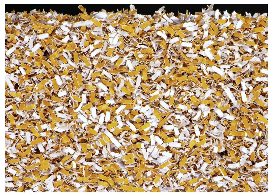 Eine Nahaufnahme von gemischtem zerrissenen Papier in Orange- und Weißtönen, die den gesamten Rahmen ausfüllt und ein strukturiertes und chaotisches Muster erzeugt.