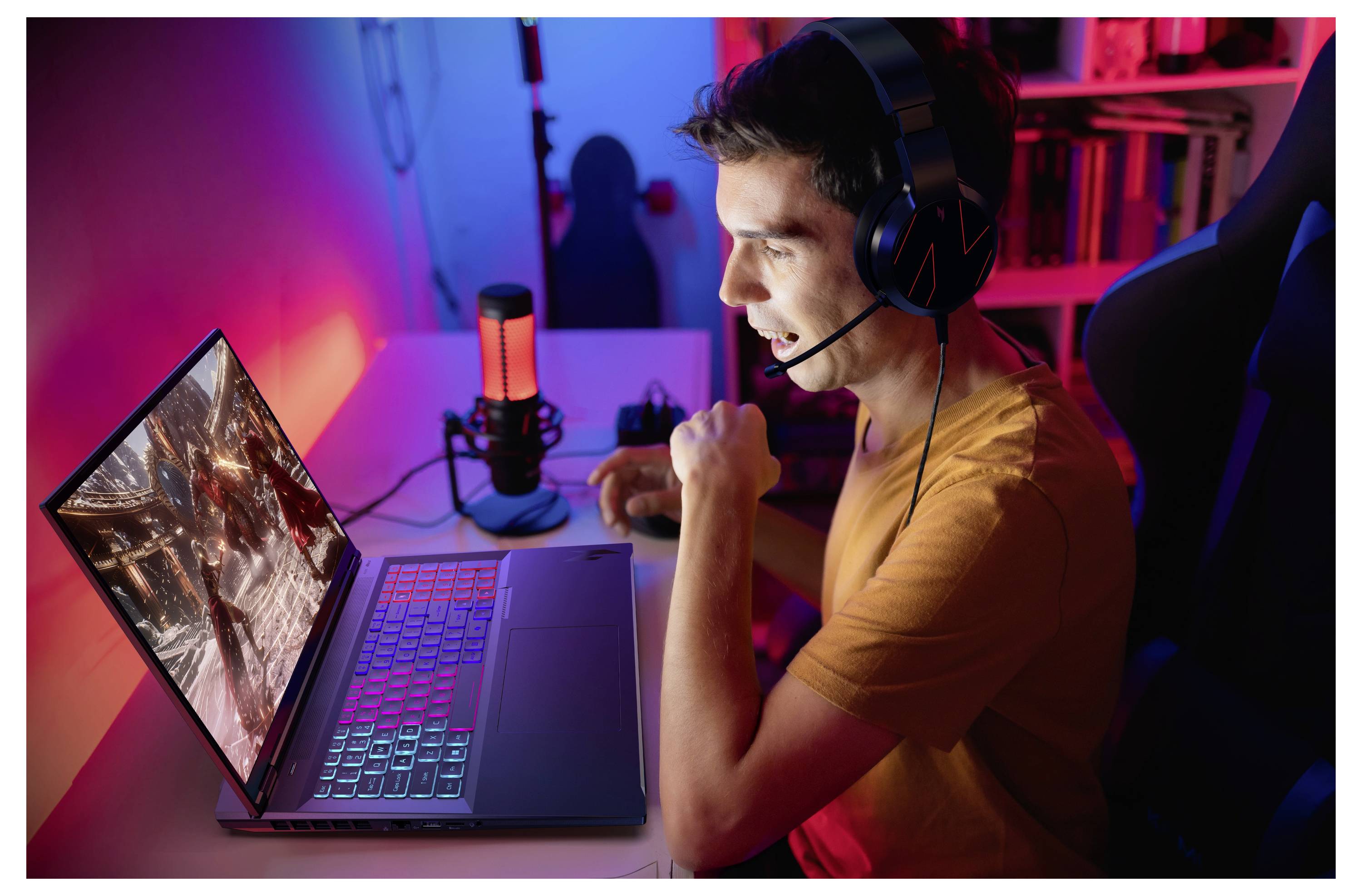 Eine Person mit Kopfhörern sitzt an einem Schreibtisch, spielt auf einem Laptop mit bunter Beleuchtung und wirkt konzentriert und vertieft.