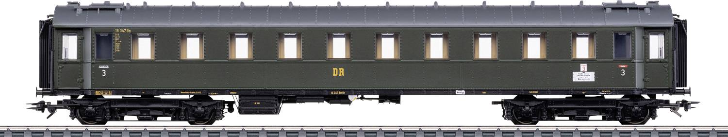 Ein nostalgischer grüner Eisenbahnwagen mit mehreren Fenstern, der auf Bahngleisen steht und seine rechteckige Form sowie Details des Untergestells betont.