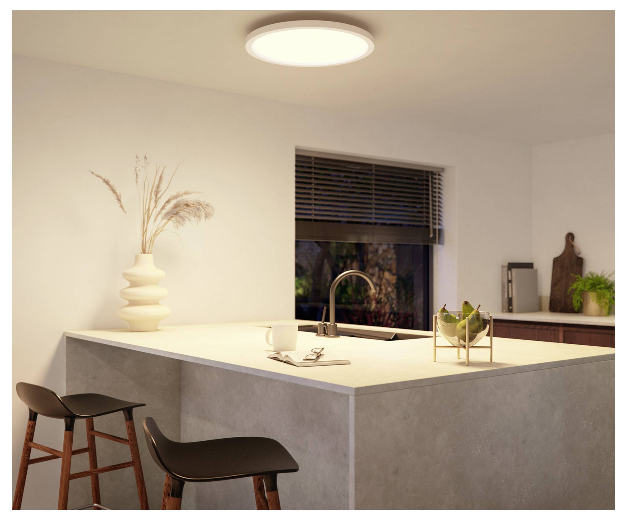 Moderne Küche mit einer eleganten Kochinsel, zwei Hockern und minimalistischer Dekoration. Weiches Deckenlicht sorgt für eine warme Atmosphäre.