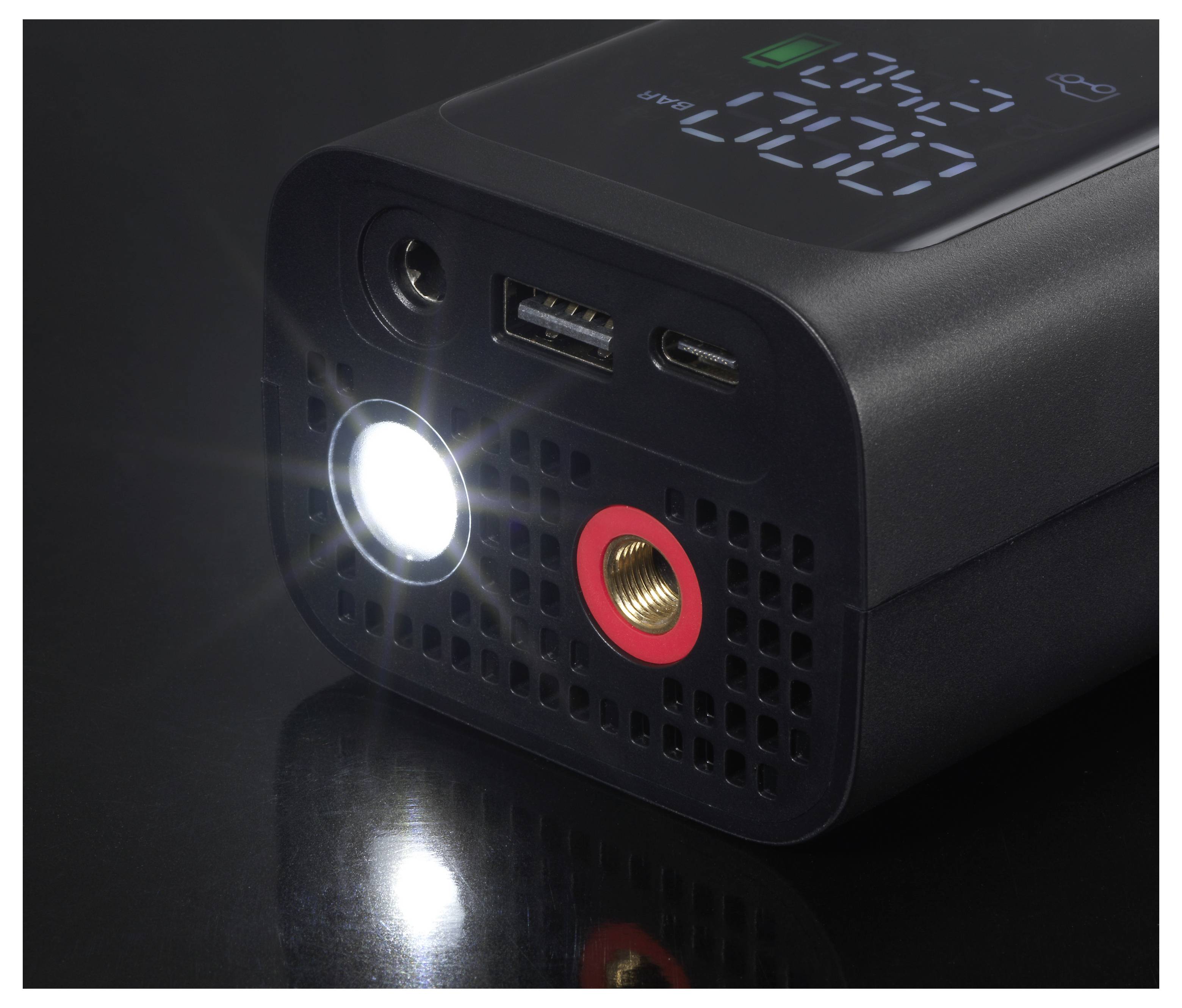 Ein tragbarer digitaler Reifenaufpumper mit einer leuchtenden Taschenlampe, USB-Anschluss und Druckmesser auf dunklem Hintergrund.