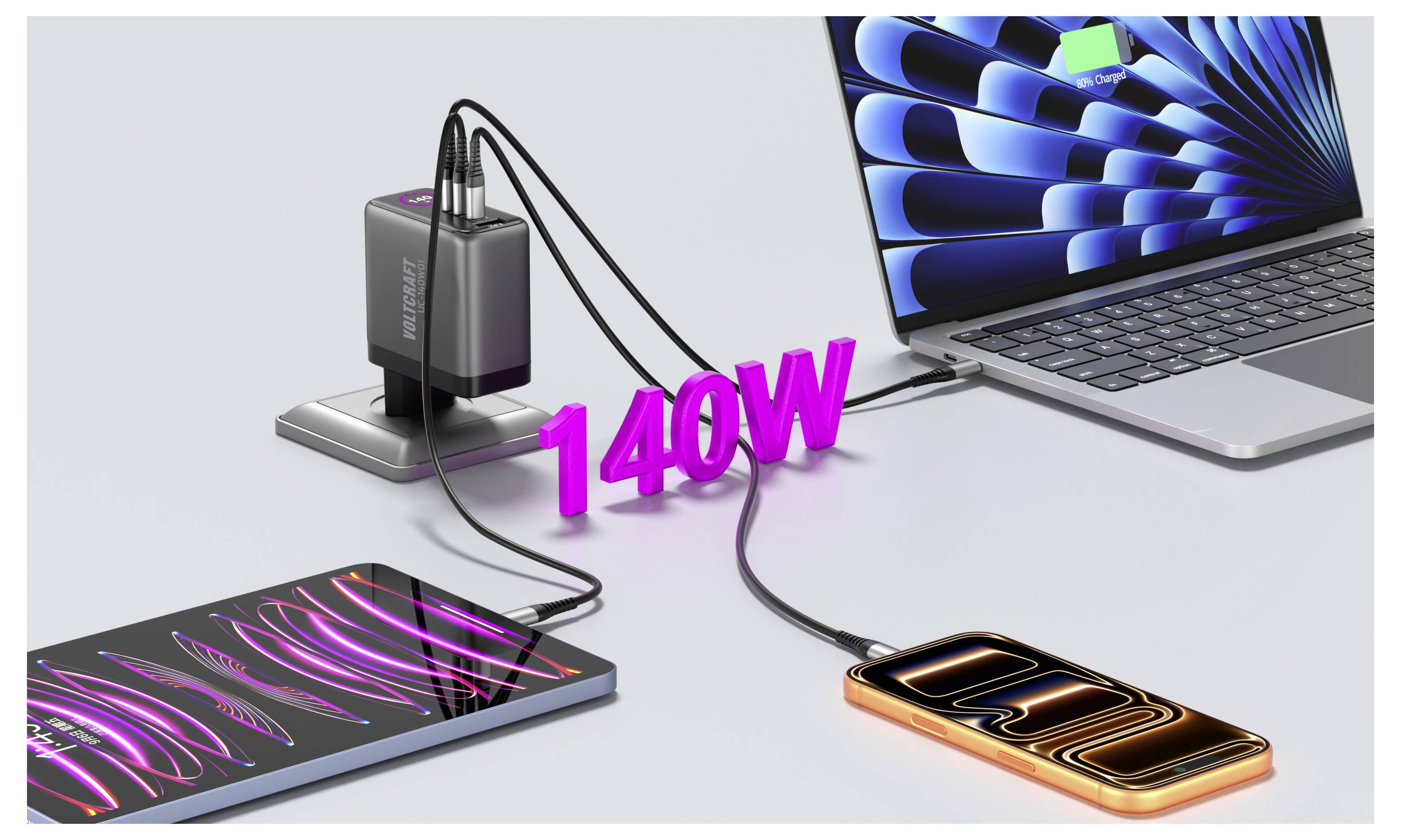 Eine Ladestation versorgt einen Laptop, ein Tablet und ein Smartphone gleichzeitig über USB-Kabel, gekennzeichnet mit „140W