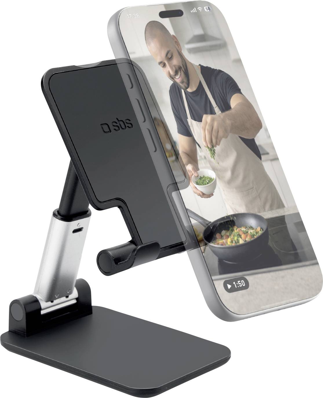 Ein Smartphone auf einem Ständer zeigt einen Mann in einer Küche, der Kräuter in eine Pfanne streut.