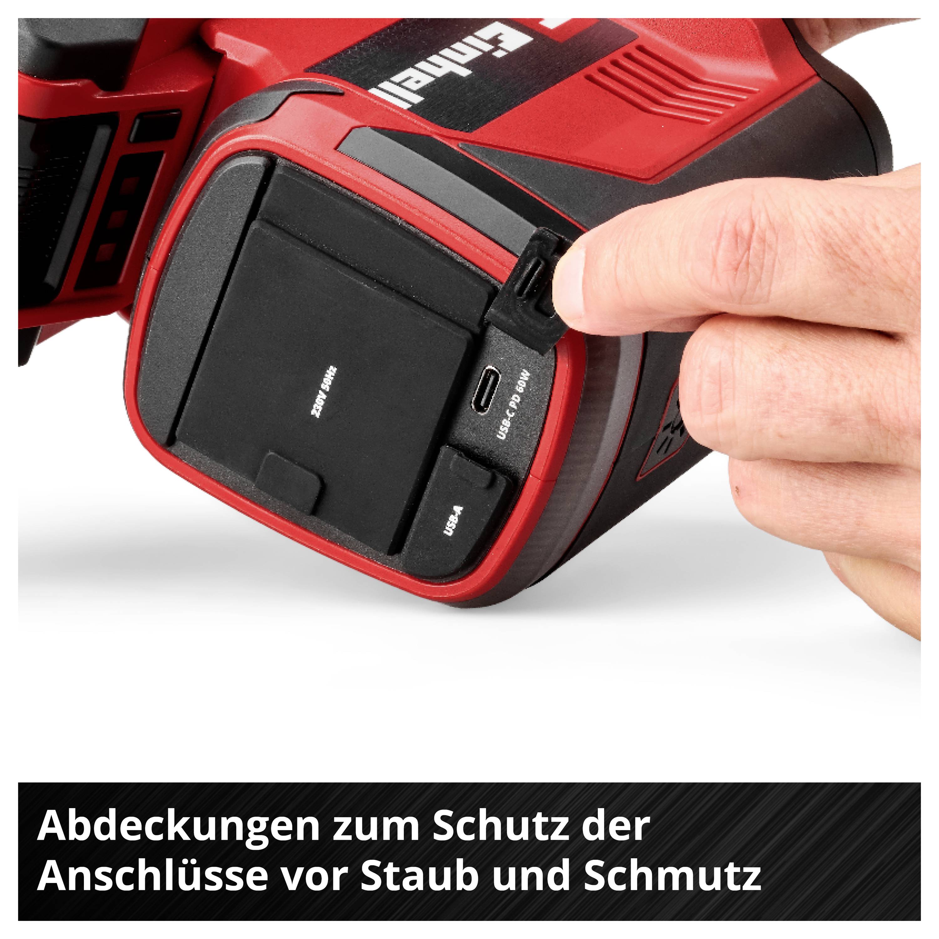 Ein rotes Gerät mit einer Hand, die eine schwarze Gummiabdeckung öffnet, um die Anschlüsse vor Staub und Schmutz zu schützen.