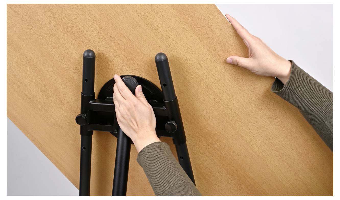 Hände, die eine Tischoberfläche mit einem Neigungsmechanismus einstellen.