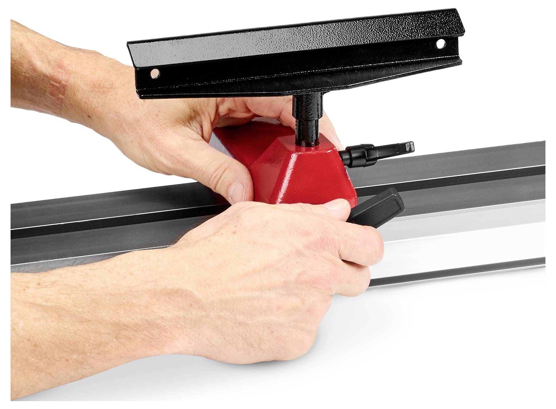 Hände, die ein rotes Werkzeug an einer schwarz-grauen Schiene justieren, möglicherweise Teil einer Mess- oder Bauausrüstungsanordnung.